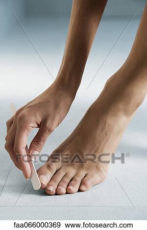 Woman giving herself a pedicure, cropped View Large Photo Image Stock Photo - Woman giving herself a pedicure, cropped. Fotosearch
