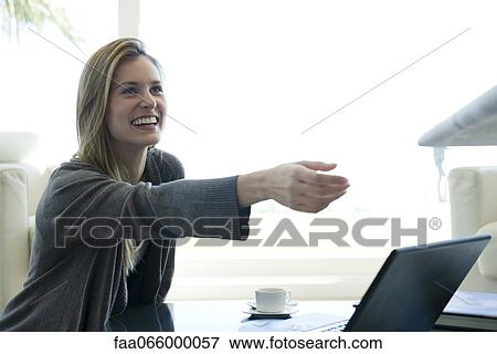 Woman reaching for paper being handed to her by person out-of-frame View Large Photo Image Stock Photo - Woman reaching for paper being handed to her by person out-of-frame. Fotosearch