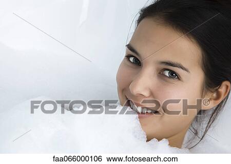 Stock Photograph - Woman relaxing in bubble bath, portrait. Fotosearch