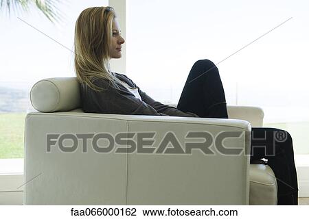 Woman sitting in armchair, side view View Large Photo Image Stock Image - Woman sitting in armchair, side view. Fotosearch