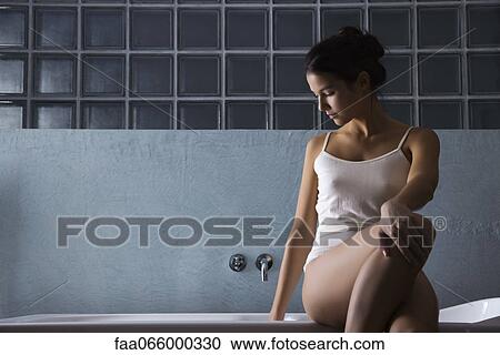 Woman sitting on edge of bathtub in underwear View Large Photo Image Stock Image - Woman sitting on edge of bathtub in underwear. Fotosearch