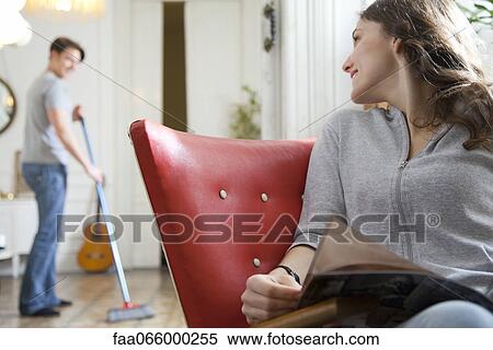 Woman smiling over shoulder at husband as he sweeps the floor View Large Photo Image Stock Photography - Woman smiling over shoulder at husband as he sweeps the floor. Fotosearch