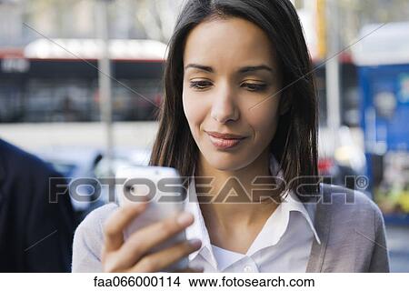 Woman text messaging outdoors View Large Photo Image Picture - Woman text messaging outdoors. Fotosearch