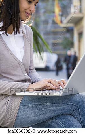 Woman using laptop computer outdoors View Large Photo Image Stock Image - Woman using laptop computer outdoors. Fotosearch