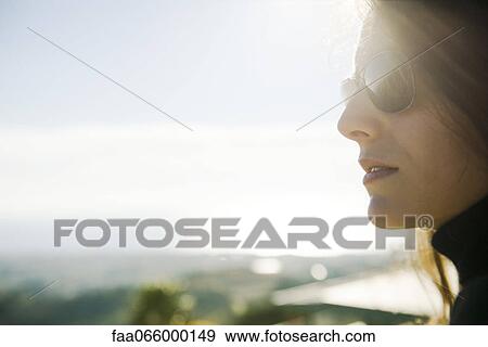 Stock Photo - Woman wearing sunglasses, portrait. Fotosearch