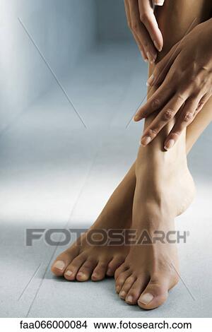 Woman's hand touching her bare feet View Large Photo Image Picture - Woman's hand touching her bare feet. Fotosearch