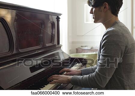 Stock Image - Young man playing piano. Fotosearch