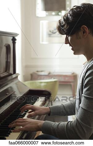 Young man playing piano View Large Photo Image Stock Photo - Young man playing piano. Fotosearch
