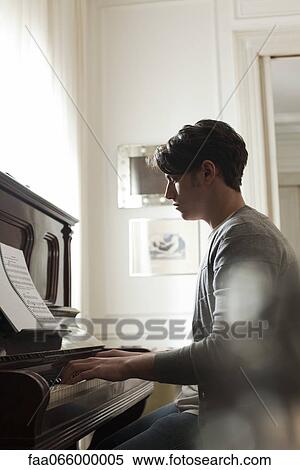 Stock Photography - Young man playing piano. Fotosearch