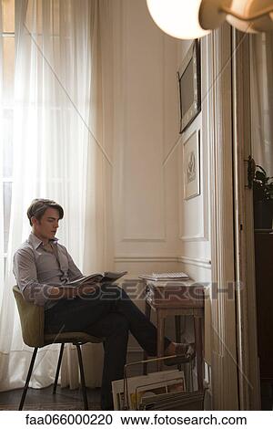 Young man reading magazine View Large Photo Image Stock Image - Young man reading magazine. Fotosearch