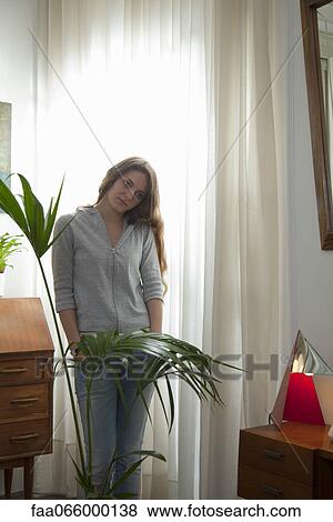 Young woman standing with hands in pockets and sad look on face View Large Photo Image Stock Photo - Young woman standing with hands in pockets and sad look on face. Fotosearch