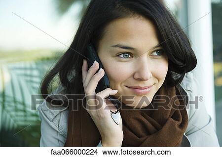 Young woman using cell phone, portrait View Large Photo Image Picture - Young woman using cell phone, portrait. Fotosearch