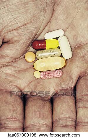 Assorted pills in man's hand View Large Photo Image Stock Photo - Assorted pills in man's hand. Fotosearch