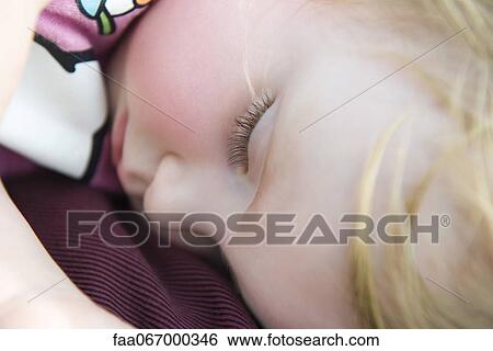 Stock Photograph - Baby girl napping, close-up. Fotosearch