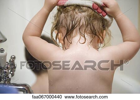 Stock Image - Baby girl taking a bath, rear view. Fotosearch
