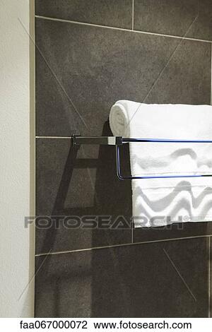 Stock Image - Bath towel folded over towel rack. Fotosearch