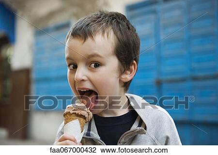 Boy licking ice cream cone, portrait View Large Photo Image Stock Image - Boy licking ice cream cone, portrait. Fotosearch