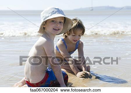 Boy playing with sister at the beach View Large Photo Image Picture - Boy playing with sister at the beach. Fotosearch