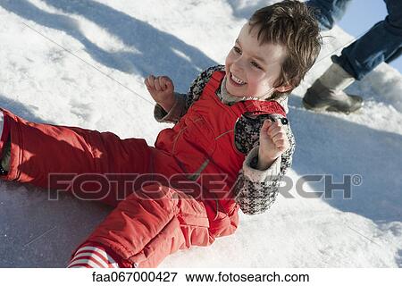 Boy sitting in snow, smiling View Large Photo Image Stock Photo - Boy sitting in snow, smiling. Fotosearch