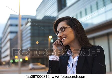 Stock Image - Business woman talking on cell phone, portrait. Fotosearch