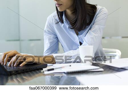 Stock Photo - Businesswoman using laptop, cropped. Fotosearch