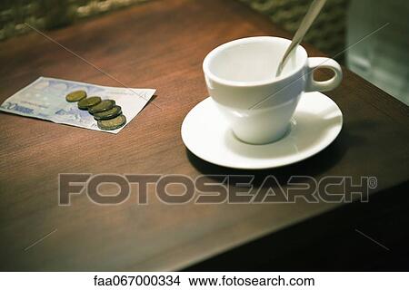 Picture - Empty coffee cup and money on table. Fotosearch