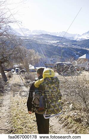 Stock Photo - Father hiking on trail, carrying baby in backpack. Fotosearch