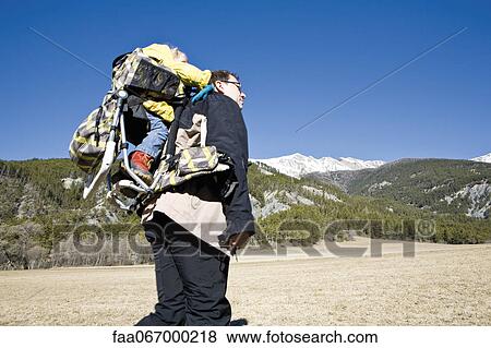 Father hiking with baby in backpack carrier View Large Photo Image Stock Photo - Father hiking with baby in backpack carrier. Fotosearch