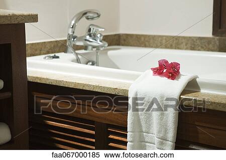 Fresh towel decorated with flower heads hanging on edge of bathtub View Large Photo Image Stock Photography - Fresh towel decorated with flower heads hanging on edge of bathtub. Fotosearch