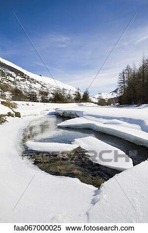 Stock Photography - Ice floes floating on river in snowy landscape. Fotosearch
