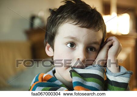 Little boy daydreaming, chewing distractedly on shirt sleeve View Large Photo Image Picture - Little boy daydreaming, chewing distractedly on shirt sleeve. Fotosearch