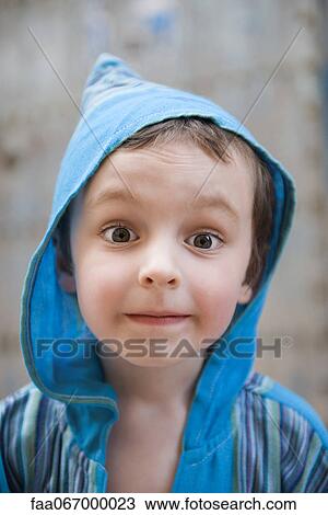 Stock Image - Little boy looking at camera with surprised expression, portrait. Fotosearch