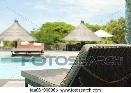Stock Photography - Lounge chair beside pool at resort. Fotosearch