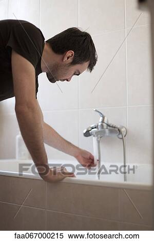 Stock Photography - Man testing water temperature. Fotosearch