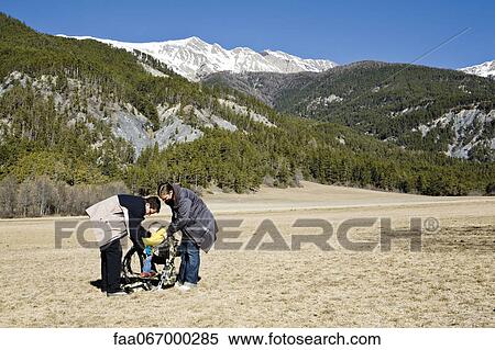 Stock Photography - Parents getting child ready in baby carrier before going on hike. Fotosearch