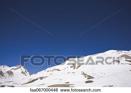 Snow-covered mountain against clear blue sky View Large Photo Image Stock Photo - Snow-covered mountain against clear blue sky. Fotosearch