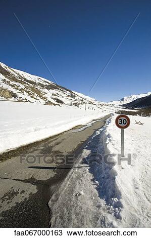 Speed limit sign on snow-covered road View Large Photo Image Stock Image - Speed limit sign on snow-covered road. Fotosearch