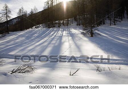 Sun setting behind mountain in snowy landscape View Large Photo Image Stock Image - Sun setting behind mountain in snowy landscape. Fotosearch