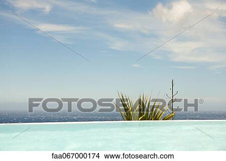 Swimming pool, sea in background View Large Photo Image Picture - Swimming pool, sea in background. Fotosearch