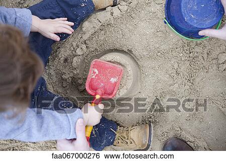 Toddler boy playing in sand View Large Photo Image Stock Photograph - Toddler boy playing in sand. Fotosearch