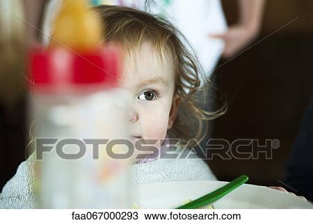 Toddler girl at table, baby bottle in foreground View Large Photo Image Stock Image - Toddler girl at table, baby bottle in foreground. Fotosearch