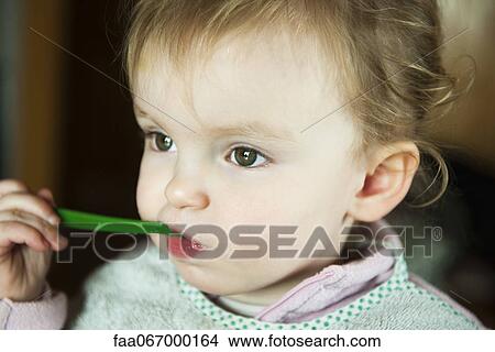 Toddler girl feeding herself, portrait View Large Photo Image Picture - Toddler girl feeding herself, portrait. Fotosearch
