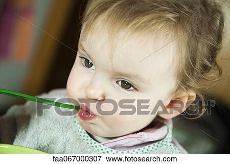 Toddler girl feeding herself, portrait View Large Photo Image Stock Photo - Toddler girl feeding herself, portrait. Fotosearch
