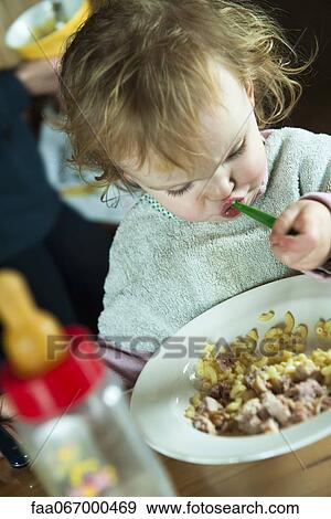 Toddler girl feeding herself View Large Photo Image Stock Photo - Toddler girl feeding herself. Fotosearch