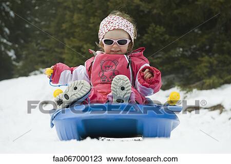 Stock Image - Toddler girl on sled. Fotosearch