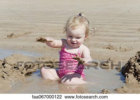 Toddler girl playing at the beach View Large Photo Image Stock Image - Toddler girl playing at the beach. Fotosearch