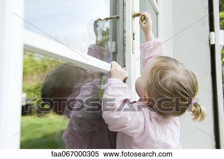Toddler girl reaching to open door View Large Photo Image Stock Photography - Toddler girl reaching to open door. Fotosearch