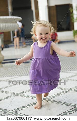 Stock Photo - Toddler girl running outdoors. Fotosearch