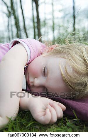 Toddler girl taking a nap outdoors View Large Photo Image Picture - Toddler girl taking a nap outdoors. Fotosearch