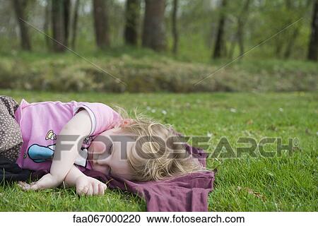 Toddler girl taking a nap outdoors View Large Photo Image Stock Image - Toddler girl taking a nap outdoors. Fotosearch